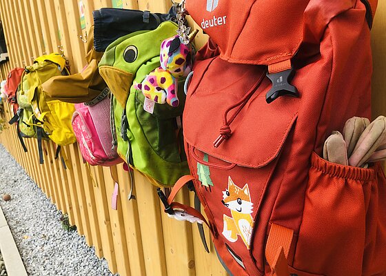 Kinderrucksäcke am Zaun vom Wegscheider Waldkindergarten